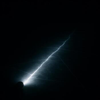 Headlamp beam cutting a thin path across dark ice at night