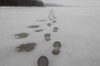 Late ice with slush patches and boot prints leading back to shore
